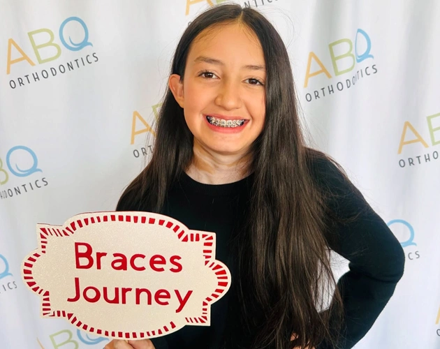Young woman smiling at ABQ Orthodontics event with "Braces Journey" graphic overlay.